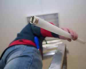 man installing fluorescent lighting system