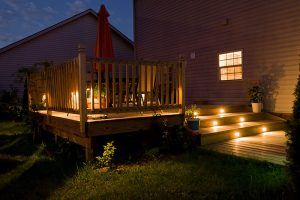 Lit up deck at night from lights in stairs and along the railing