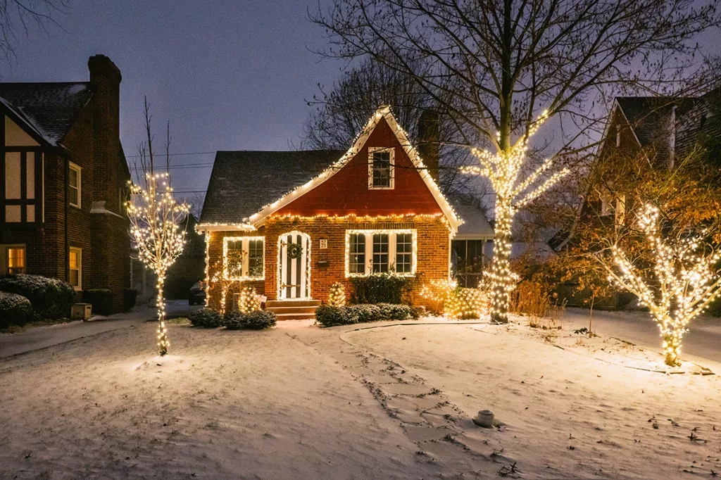 A brick house is decorated with timed white christmas lights to save energy during the holiday season.