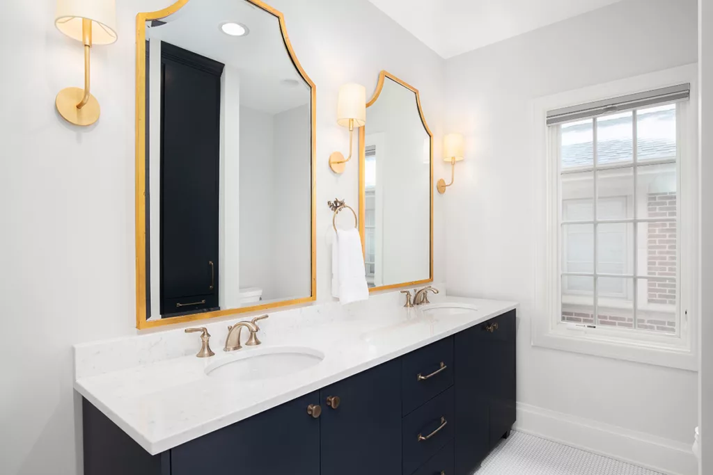 A bathroom with white walls and countertops, and warm bright LED lighting.