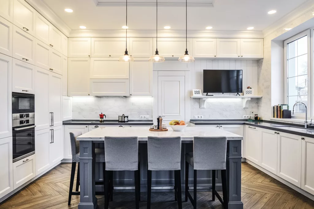 A spacious kitchen with white cabinets and bright LED lights