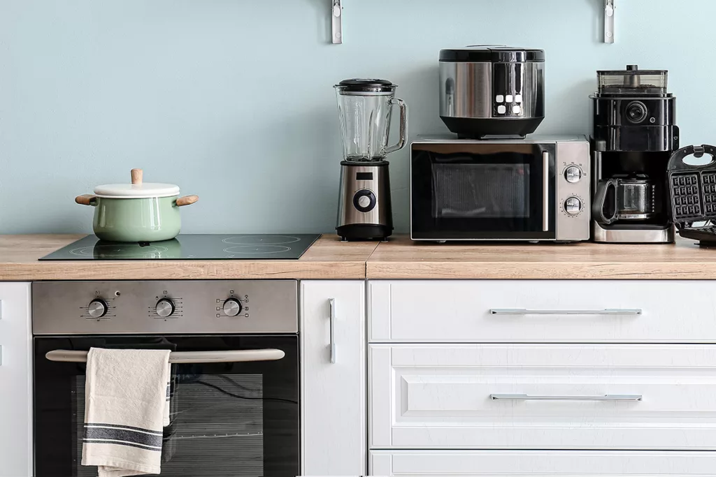 The interior of a kitchen with light blue walls and a variety of household appliances