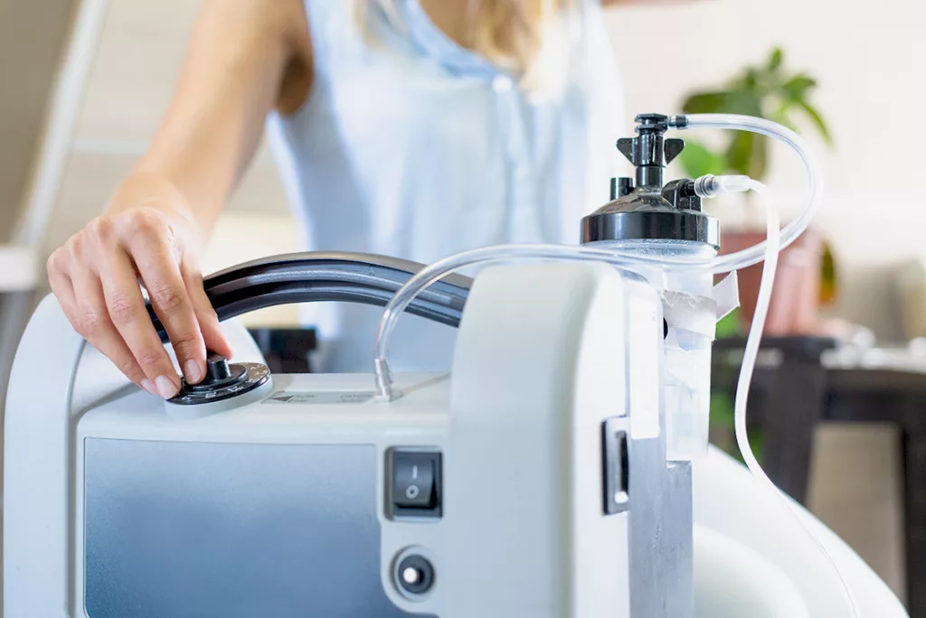 A hand adjusting an essential piece of at-home medical equipment, powered by a standby generator.