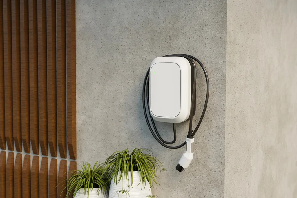 A modern EV (electric vehicle) charger installed on a home's exterior stone wall